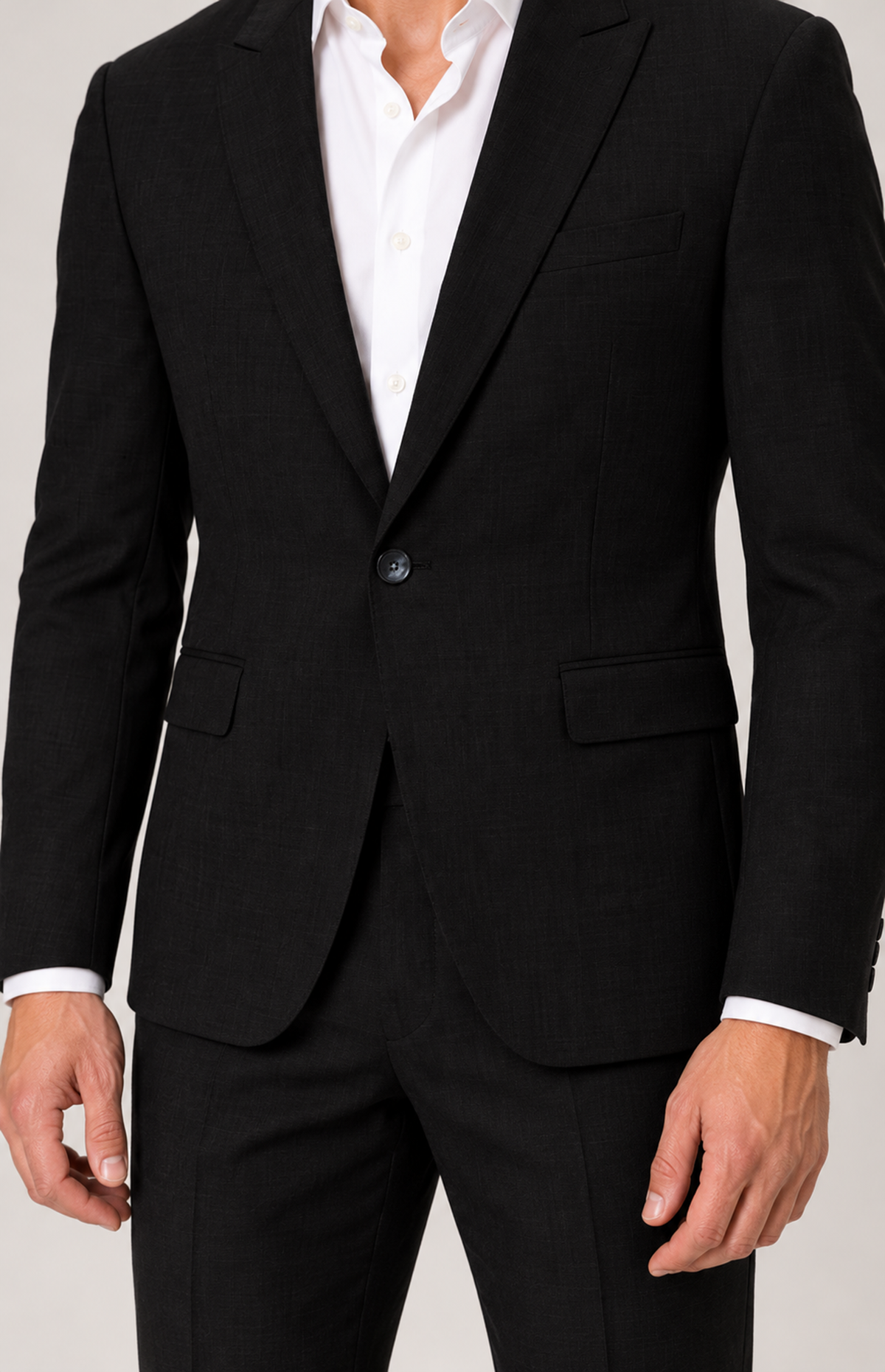 On-model detail of the black 2836 jacket front button, flap pockets and curved hem.
