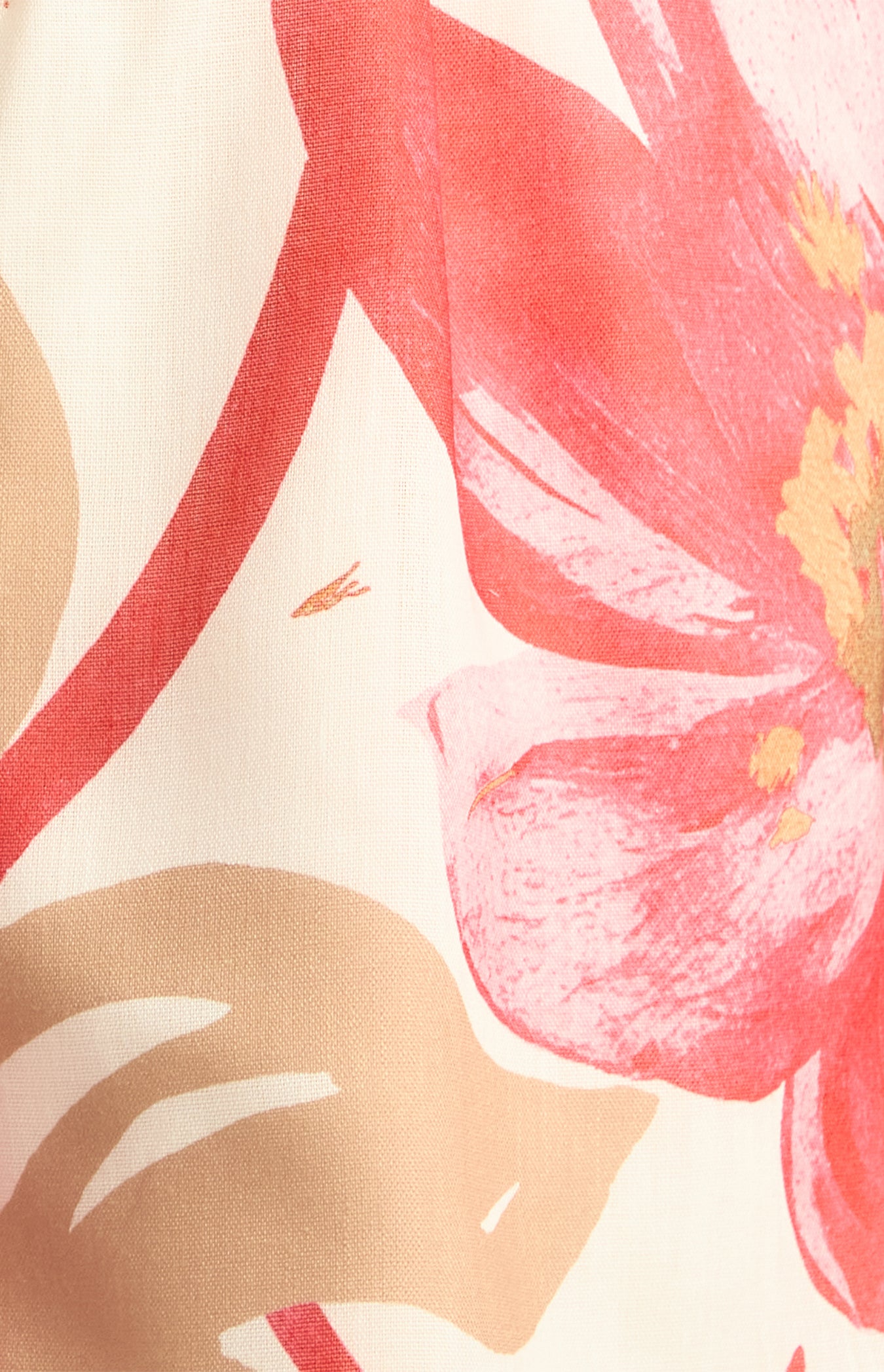 Close-up of the red and pink floral print with camel foliage on cream fabric